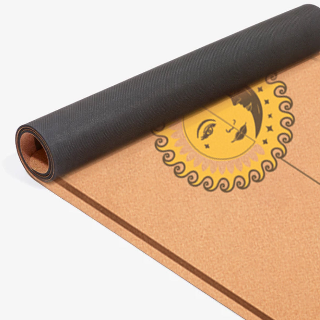 Close-up of rolled 2mm cork yoga mat with sun and moon alignment markers – thin, travel-friendly, and non-slip surface.