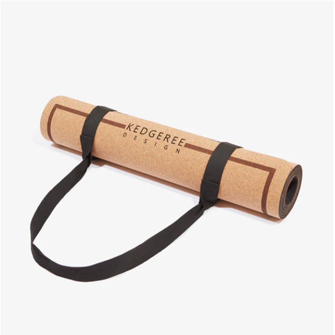 Sustainable Cork yoga mat with black strap on a white background