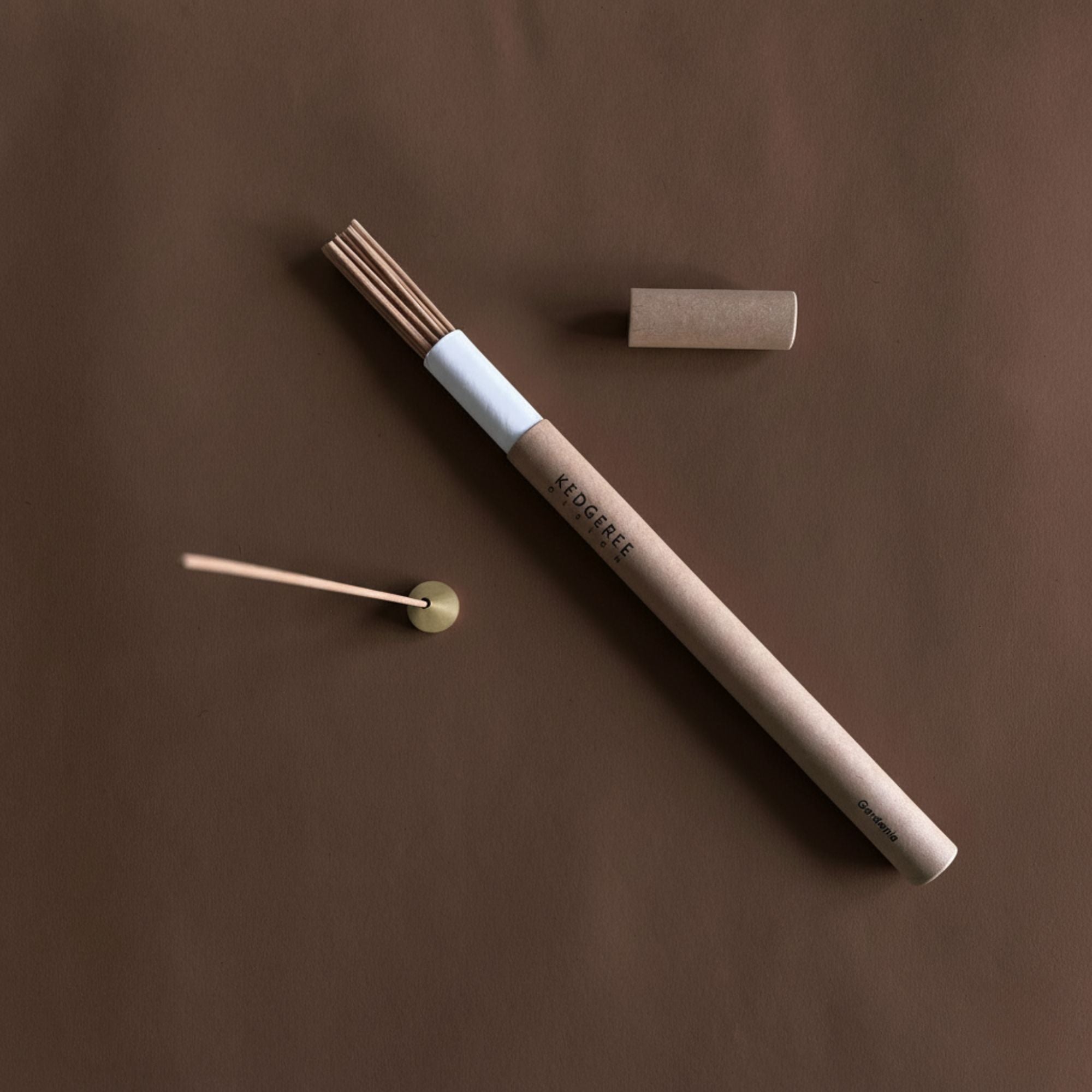 Handrolled natural incense sticks with a holder on a brown background
