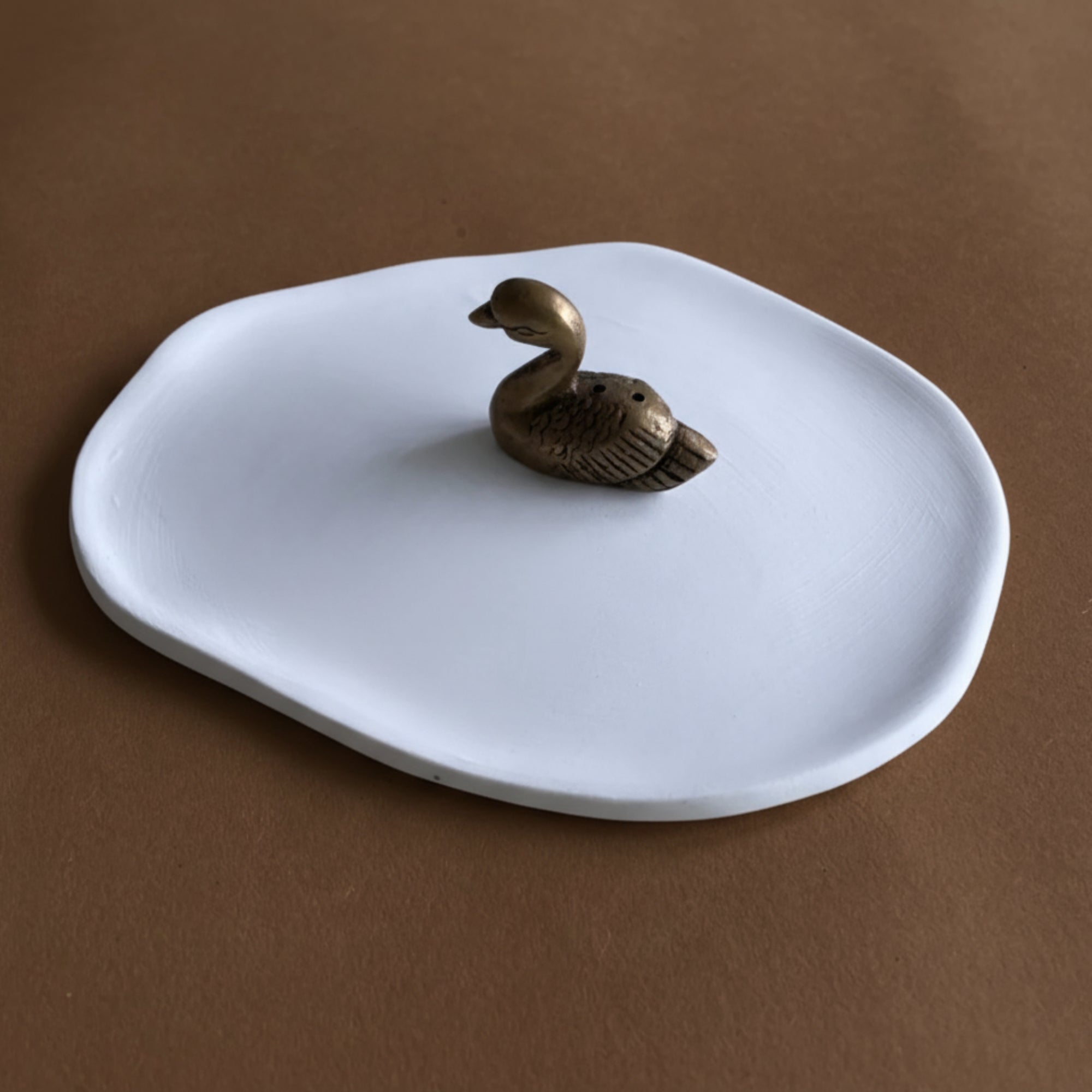 Ceramic ash-catcher tray with brass swan incense holder.