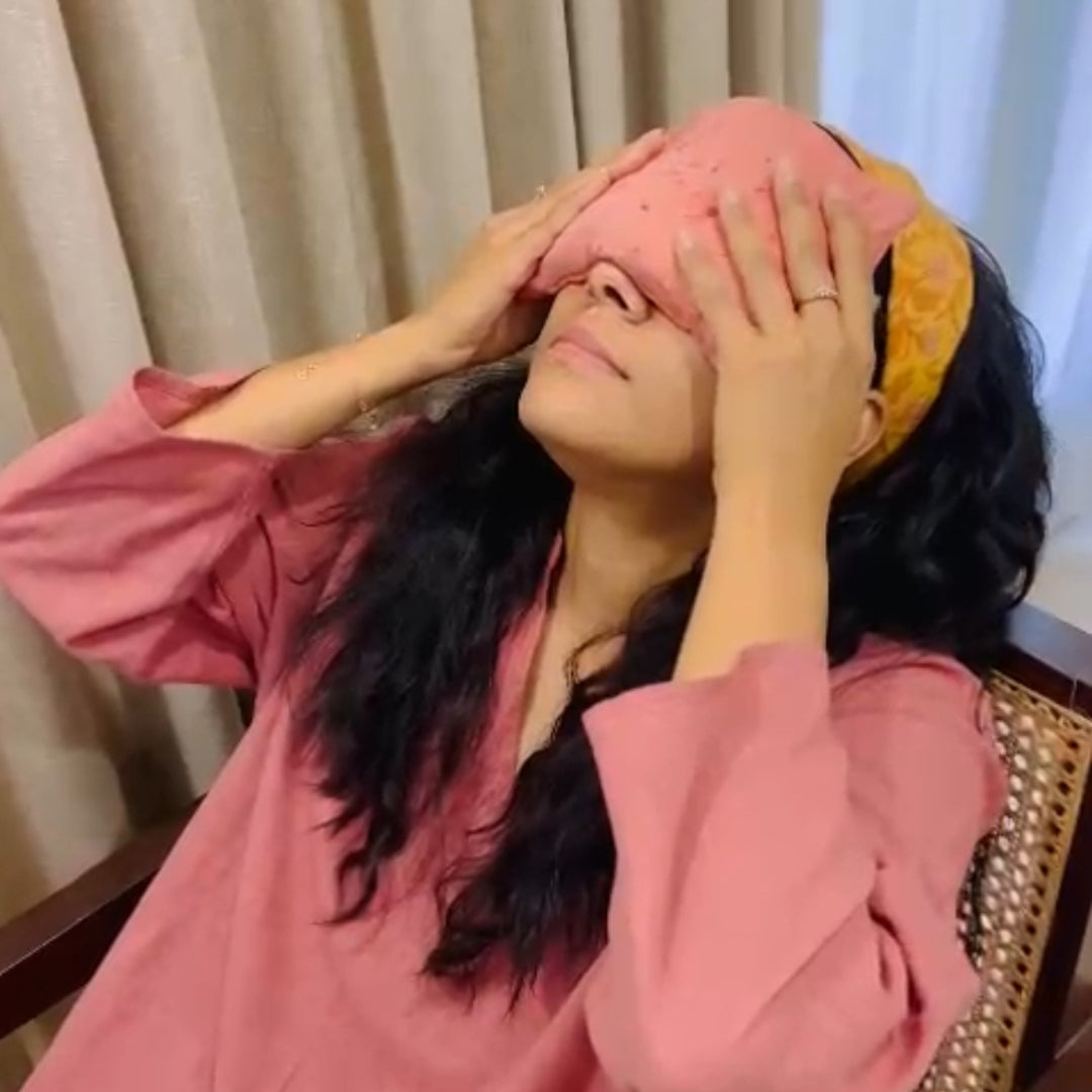 Woman using the soft eye pillow in her eye and meditating in the couch
