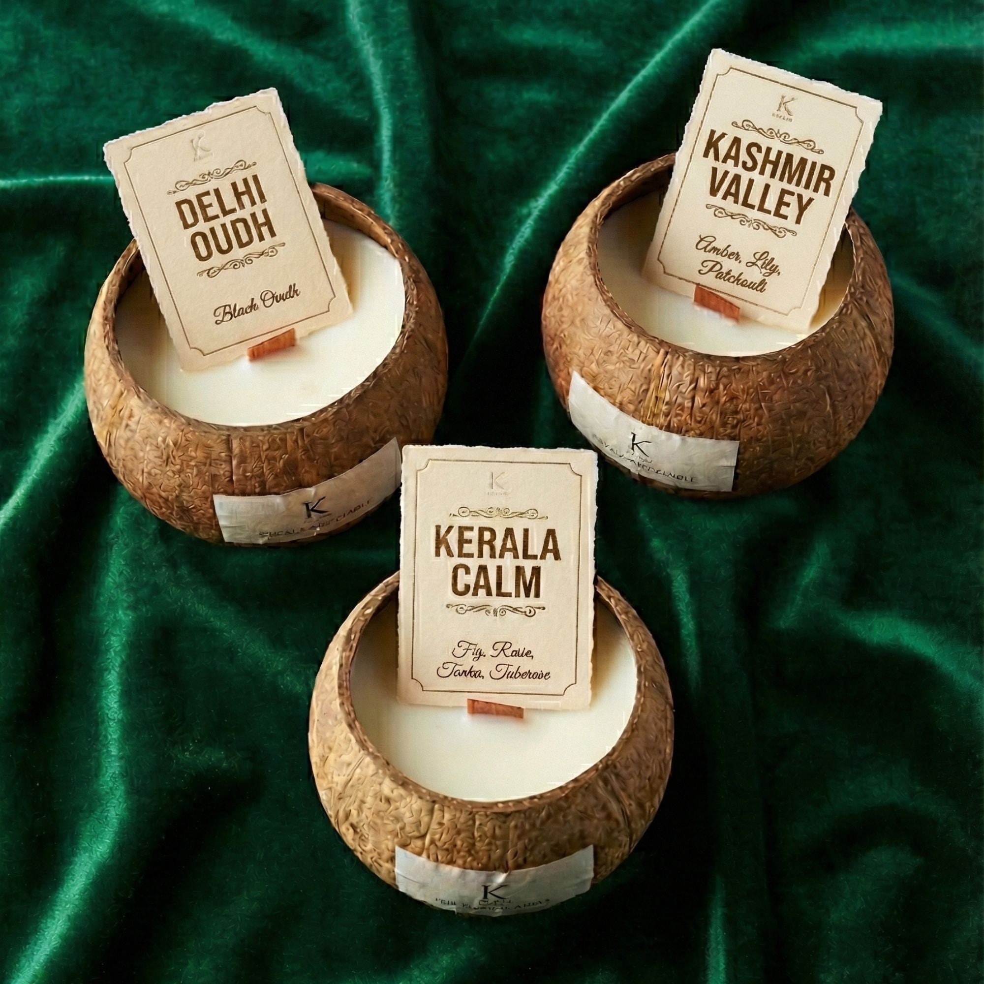 Three coconut shell plant based candles with clean burn with labeled scents on a green fabric background