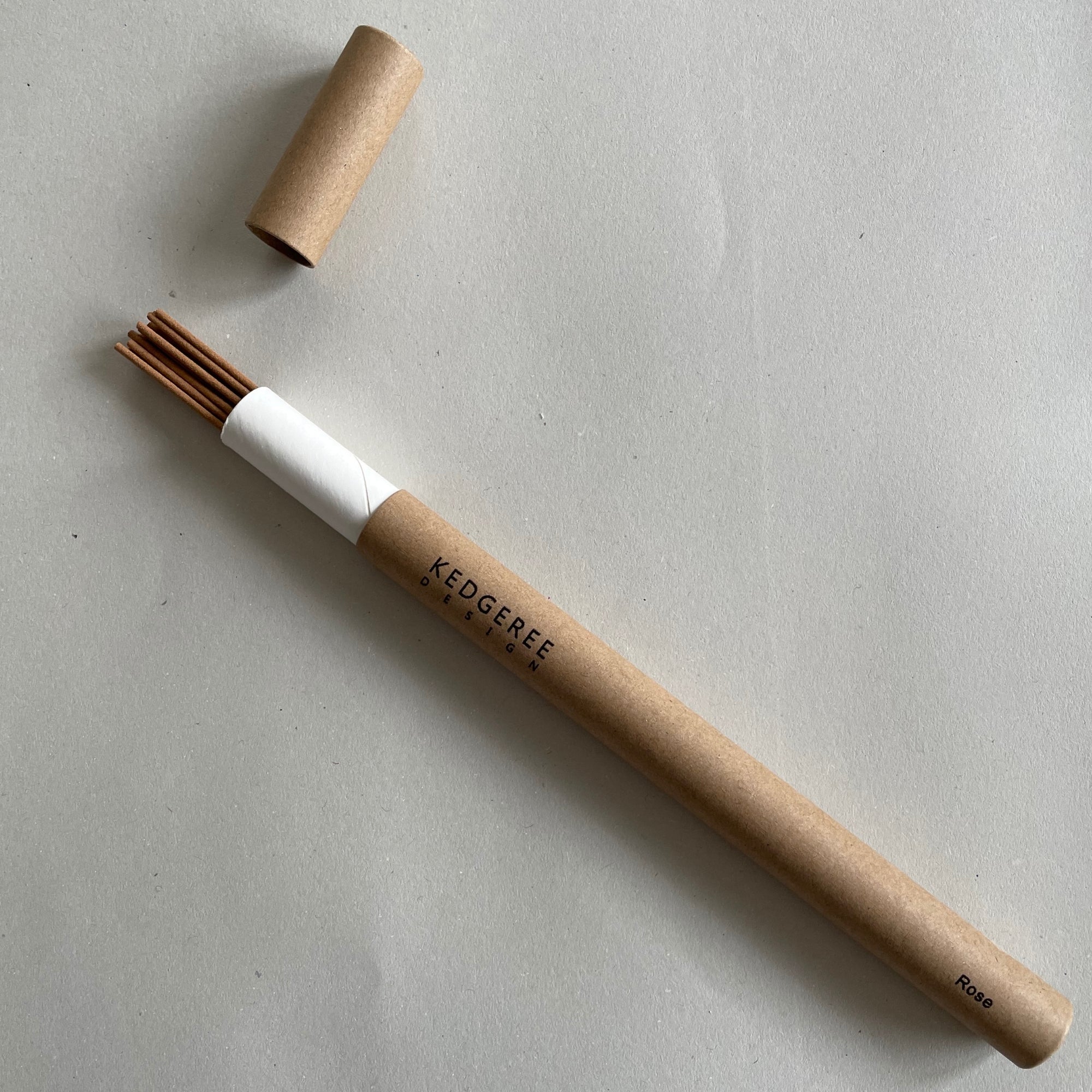 Handrolled natural Kedgeree Design rose fragrance incense holder placed against a light grey backdrop