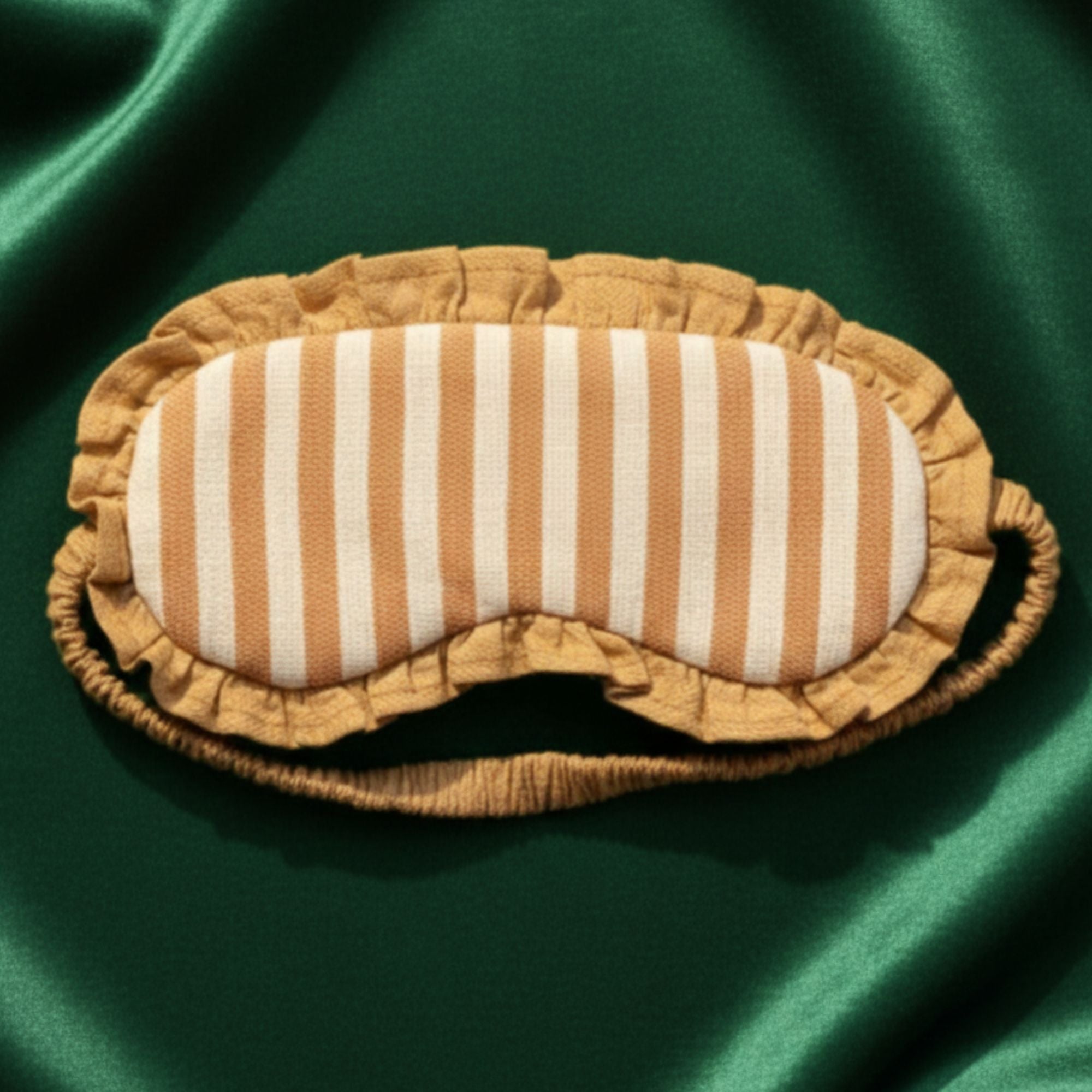 Striped linen meditation, yoga or travel eye mask on a green satin background