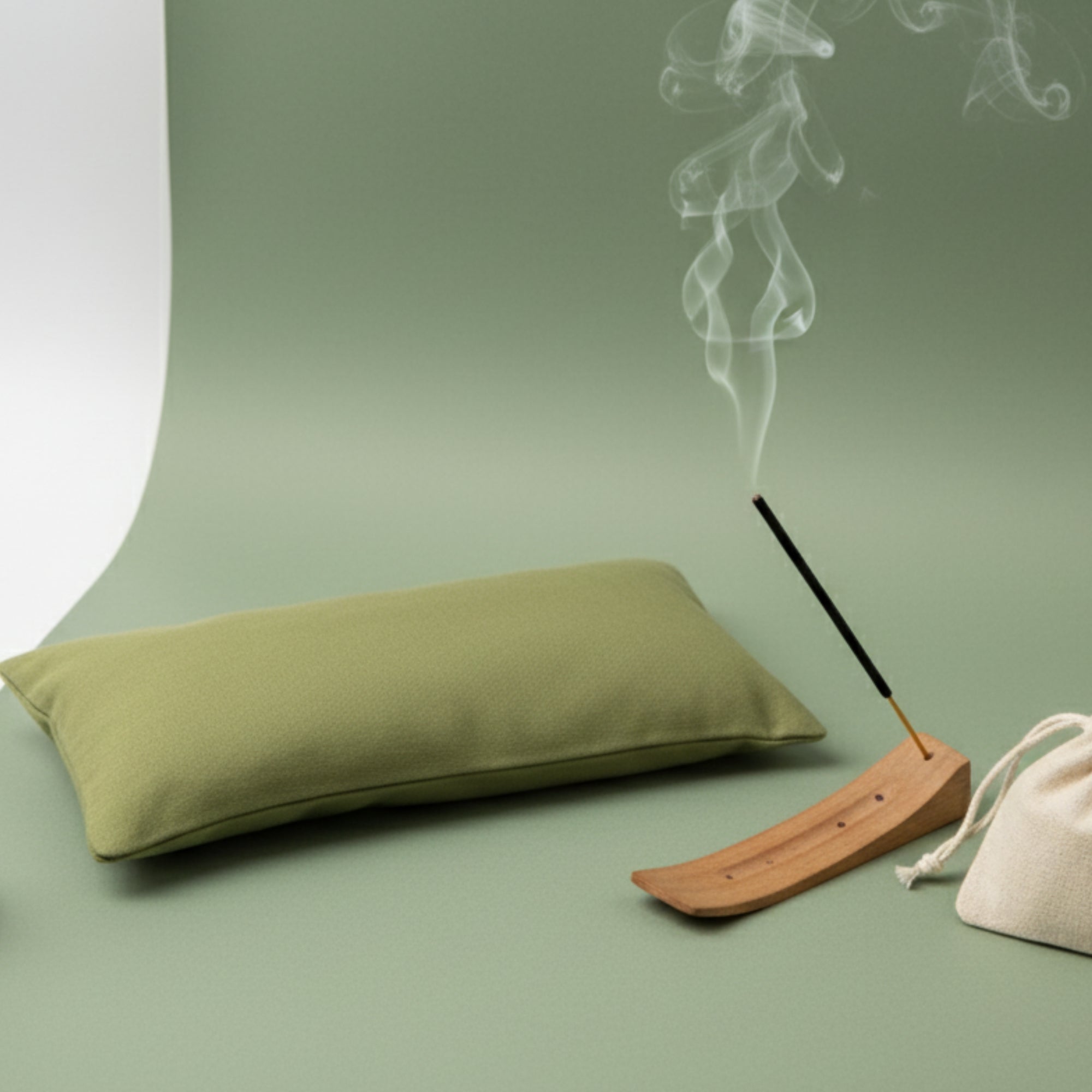 Green calming eye pillow with incense stick and smoke on a green background