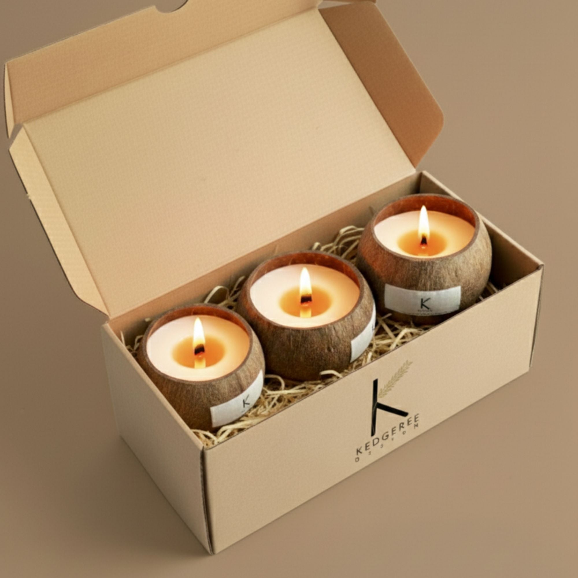 Three vegan handpoured coconut shell candles in a box with 'K' brand logo on a beige background