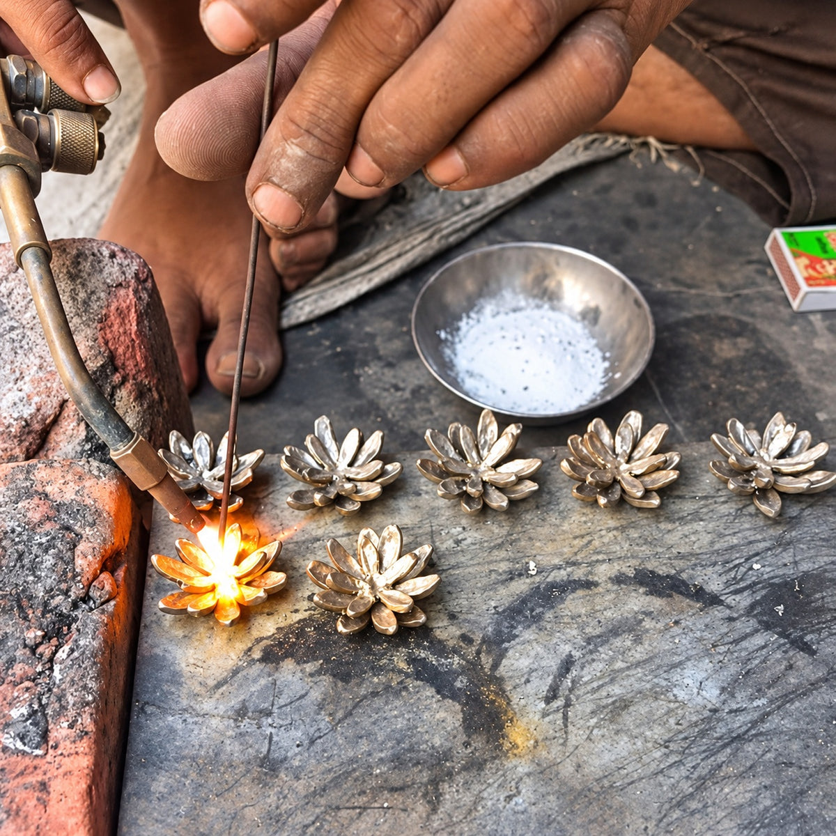 A close-up of handmade brass lotus incense holder by Kedgeree Design artisan community