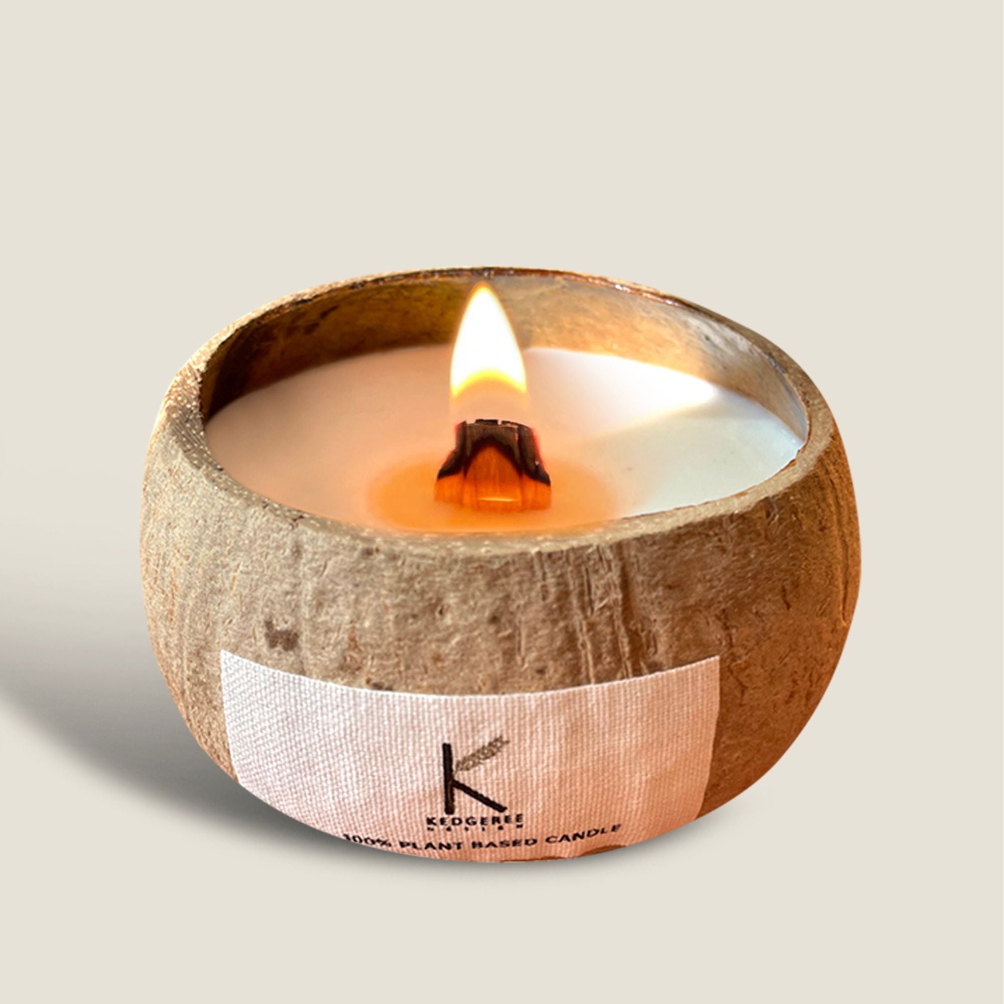 Plant based coconut shell candle with 50 hr burn time lit in the foreground