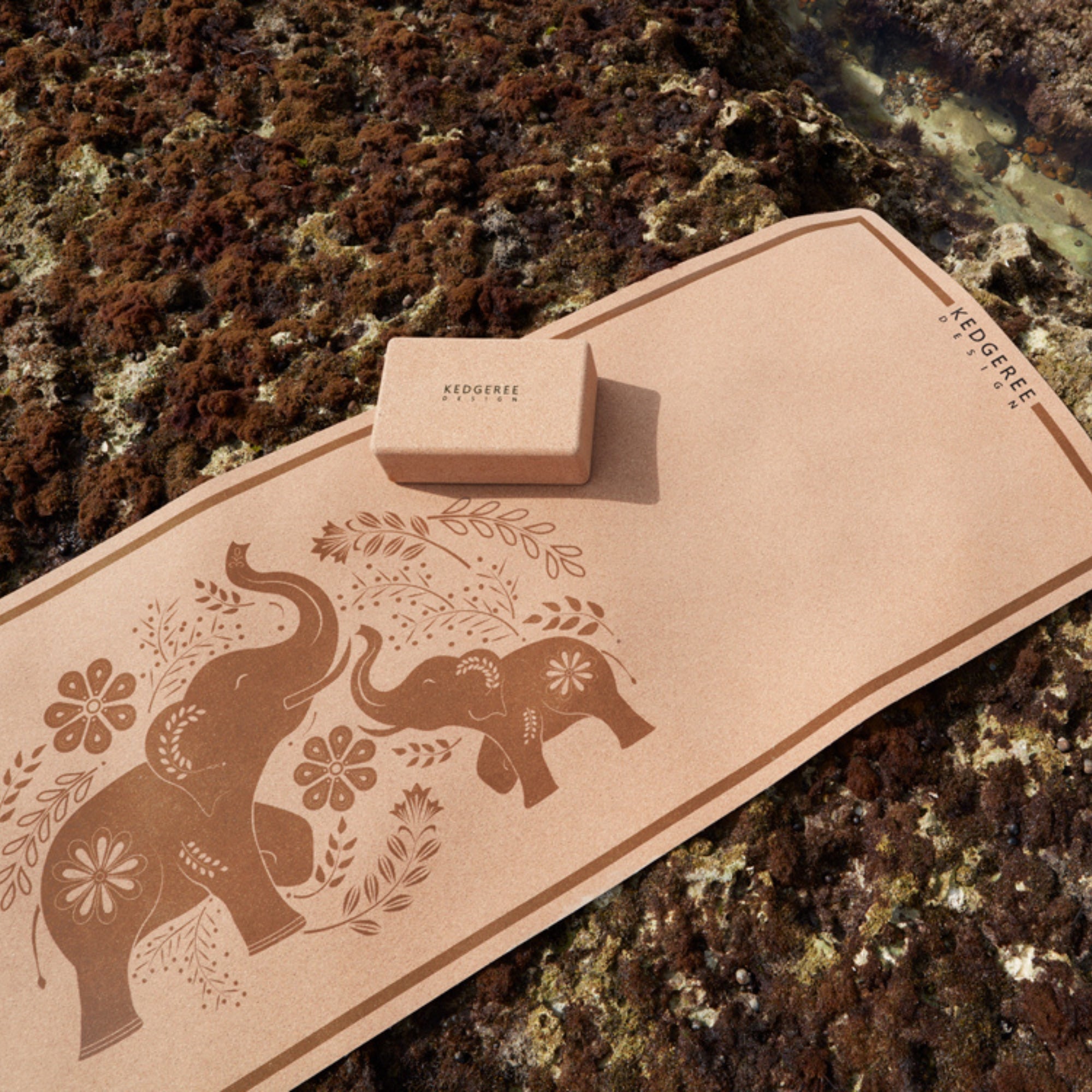 The Elephant design travel cork yoga mat on a beach from Kedgeree Design