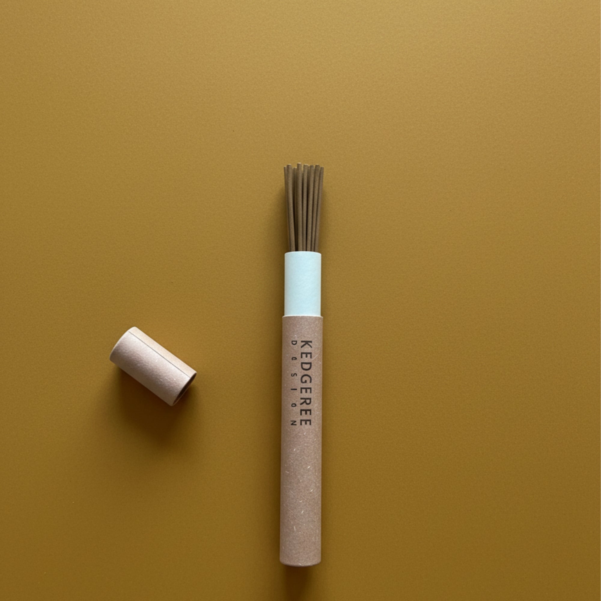 Kedgeree Design travel incense sticks with three fragrances in one - sandalwood, rose and agarwood placed against mustard yellow background