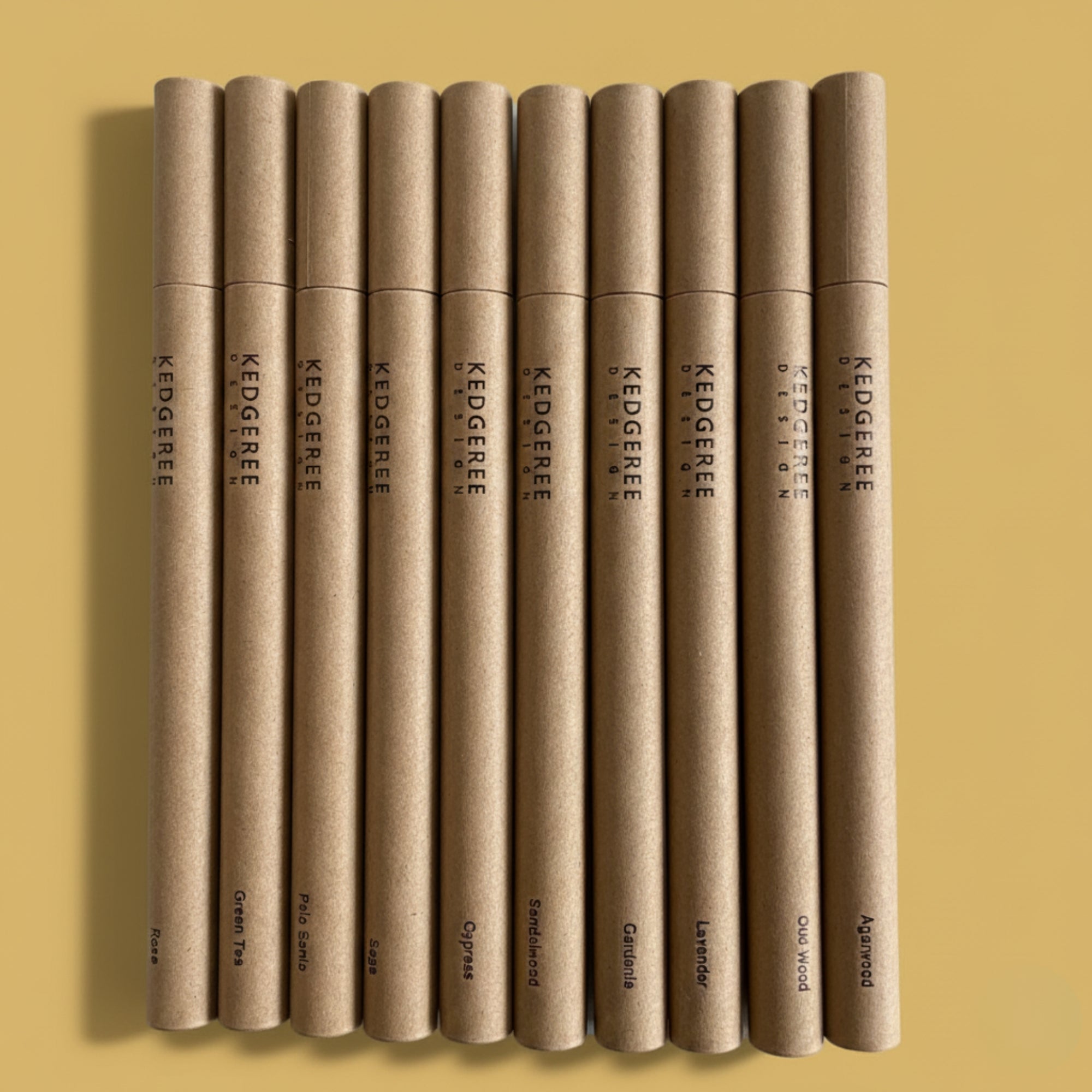 Row of Kedgeree branded hand-rolled natural incense sticks tubes on a yellow background