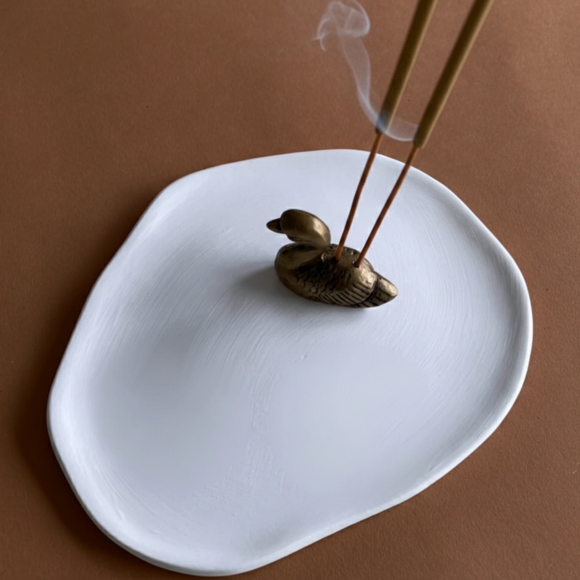 Ceramic ash-catcher tray with brass swan/Buddha head incense holder.