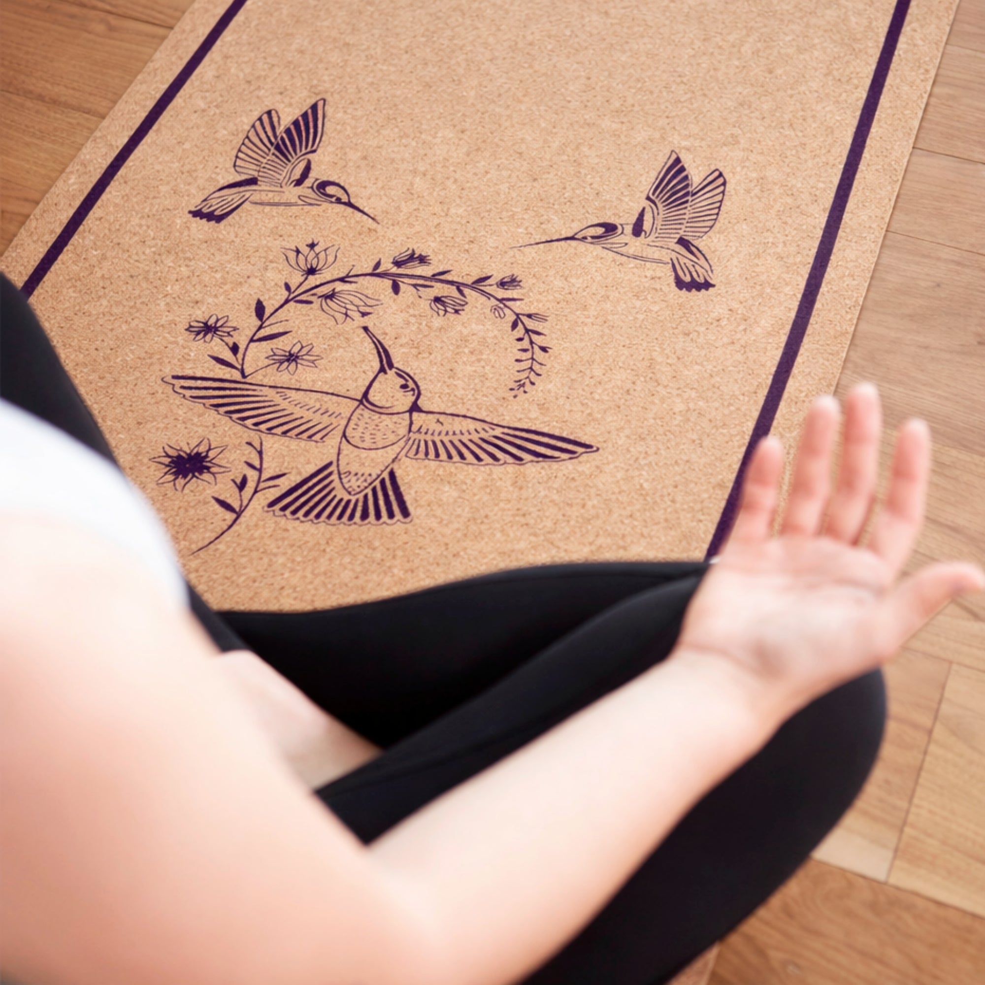 Person practicing yoga on a beautiful cork mat with bird designs