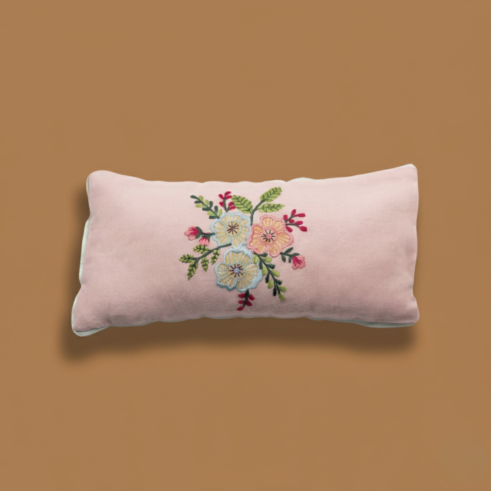 Floral embroidered eye pillow on a brown background for yoga and meditation
