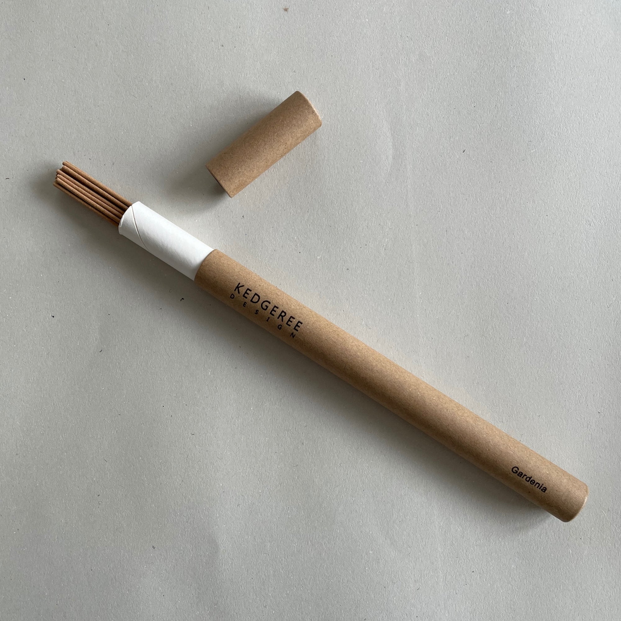 Handrolled natural Kedgeree Design floral gardenia fragrance incense holder placed against a light grey backdrop