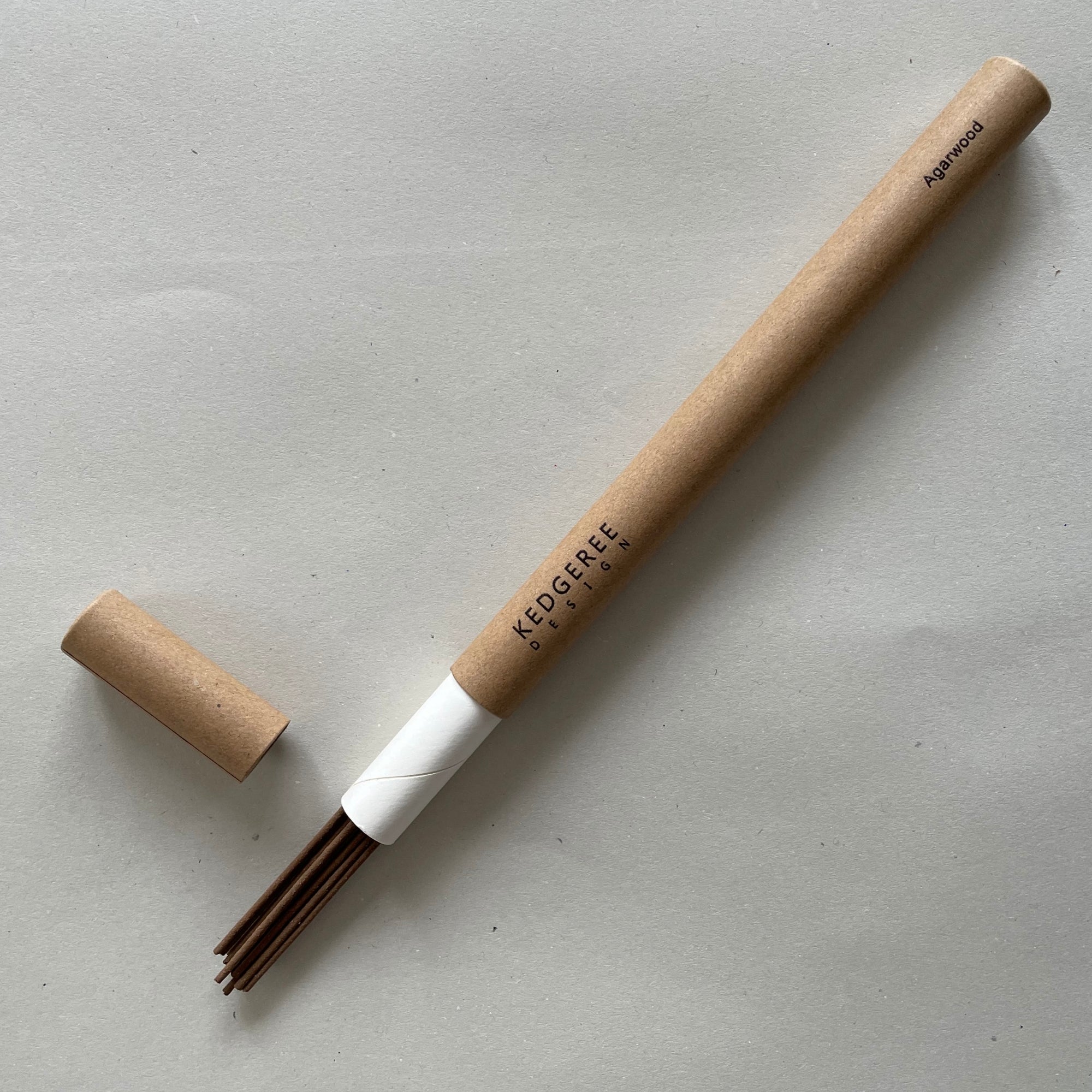Handrolled natural Kedgeree Design agarwood fragrance incense holder placed against a light grey backdrop