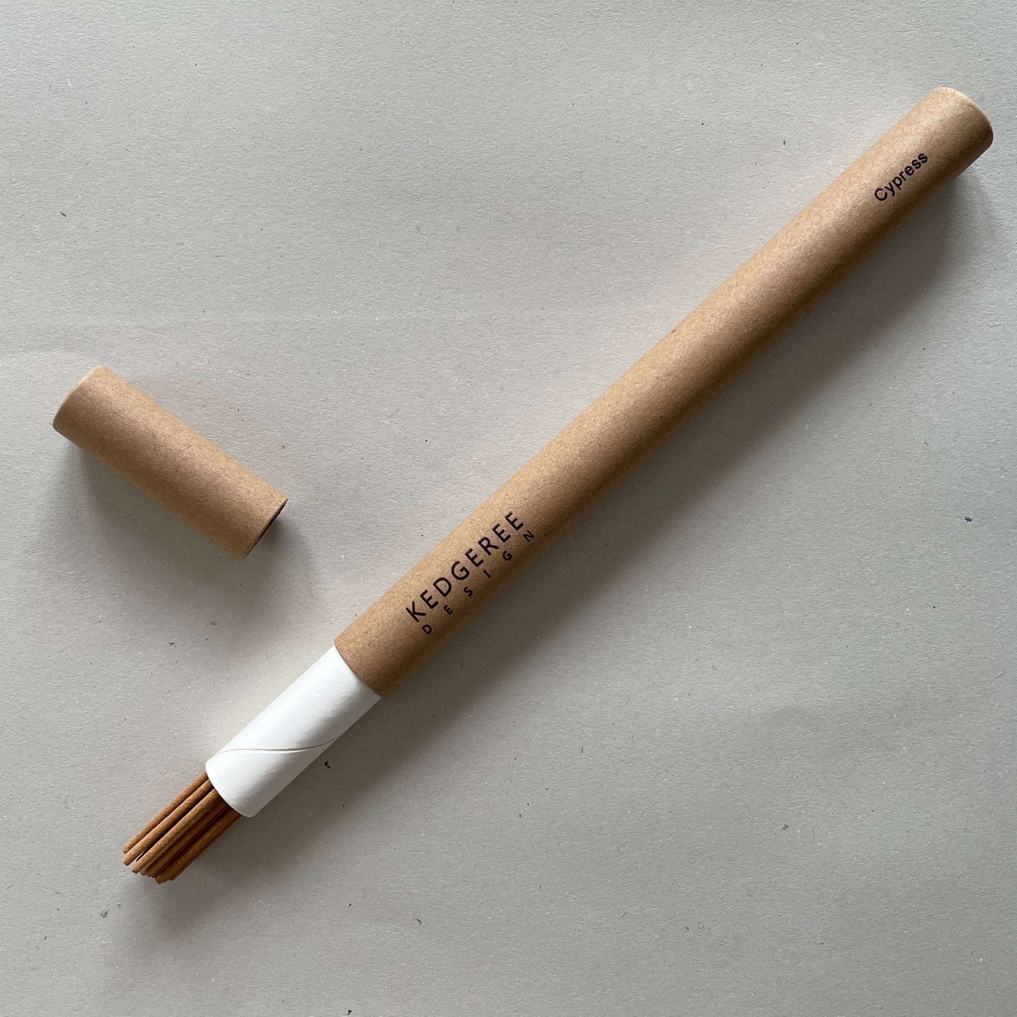 Handrolled natural Kedgeree Design cypress fragrance incense holder placed against a light grey backdrop