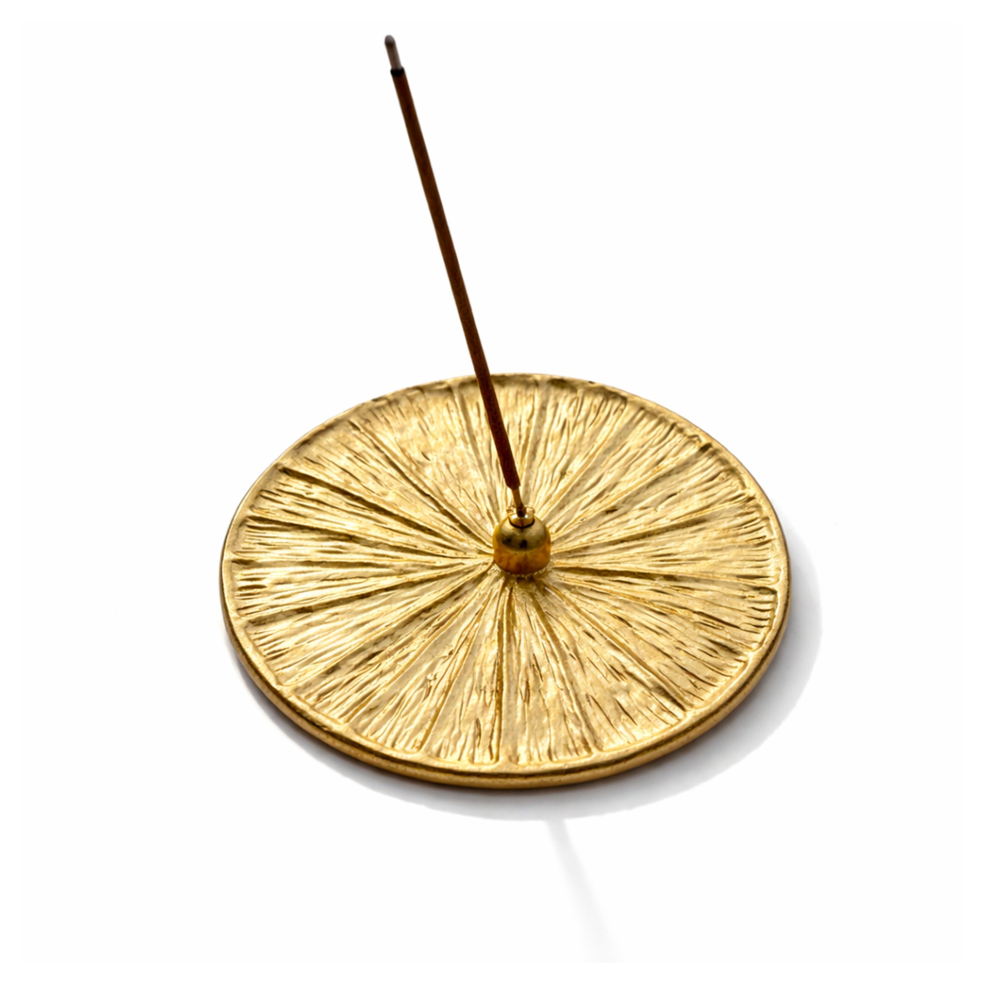 Gold incense burner with a single incense stick on a white background