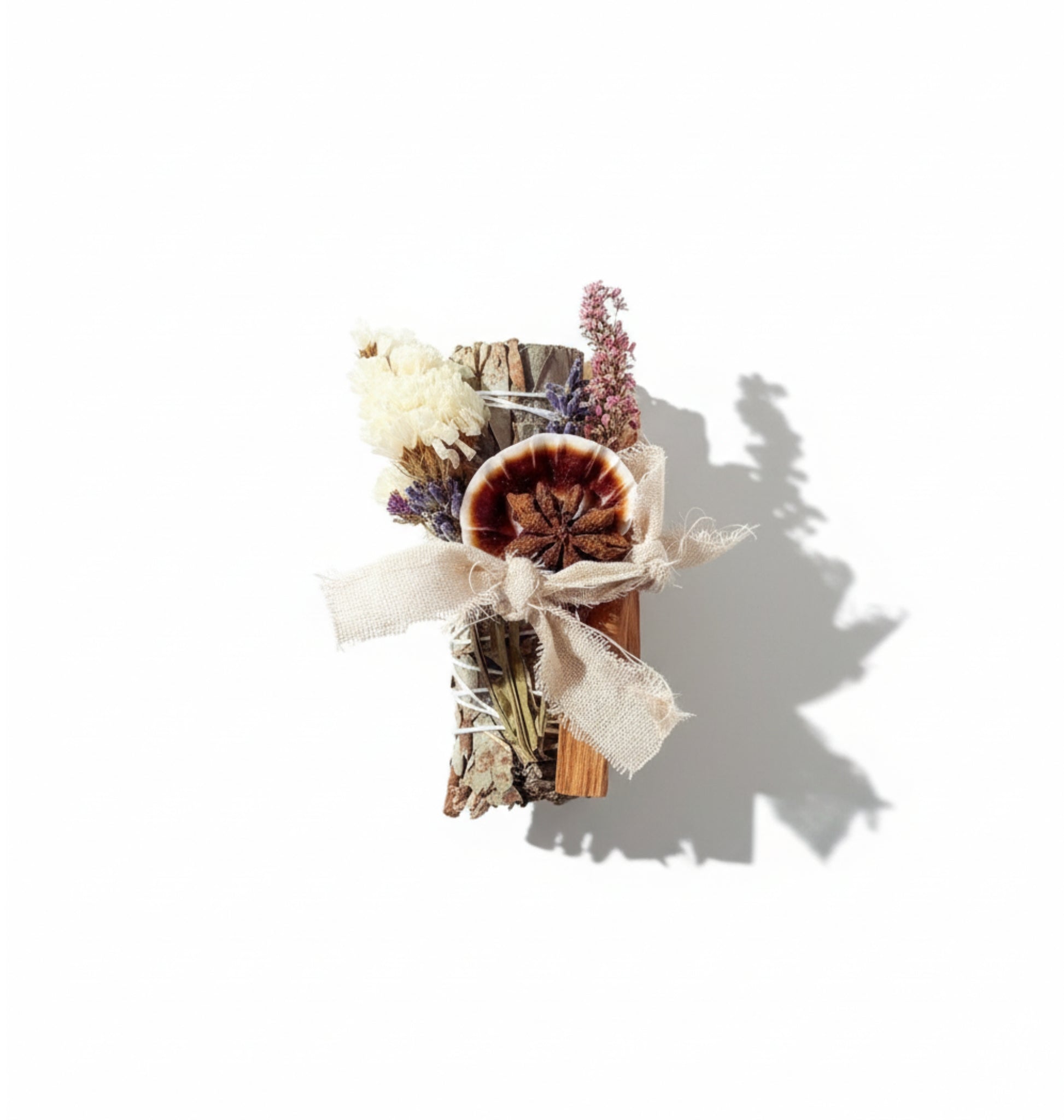 Natural Eucalyptus smudge bundle with palo santo, cinnamon sticks, star anise, and lavender on a white background