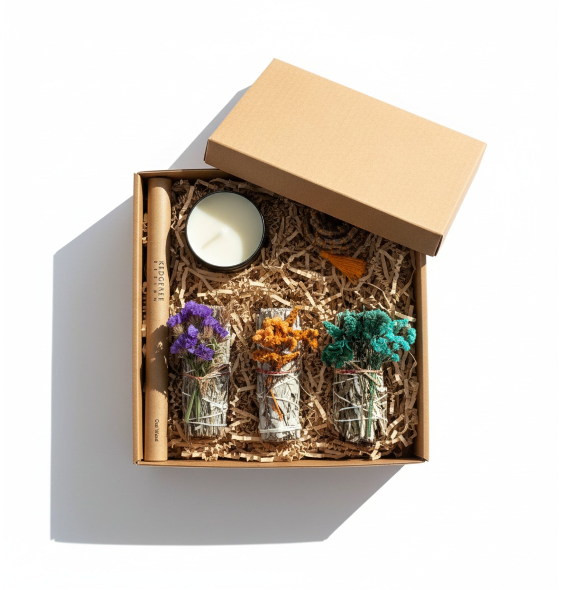 Gift set with candles, incense sticks, three sage smudge sticks  in a brown gift box on a white background