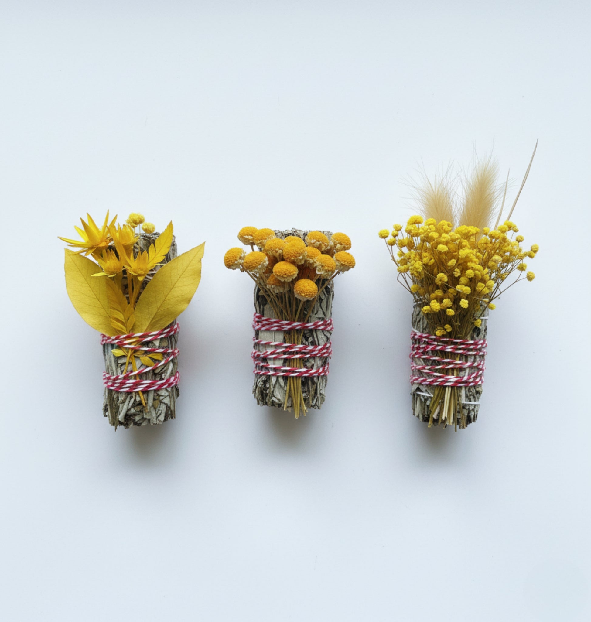 Yerba Santa Smudge bundles tied with dried flowers tied and ribbons on a white background