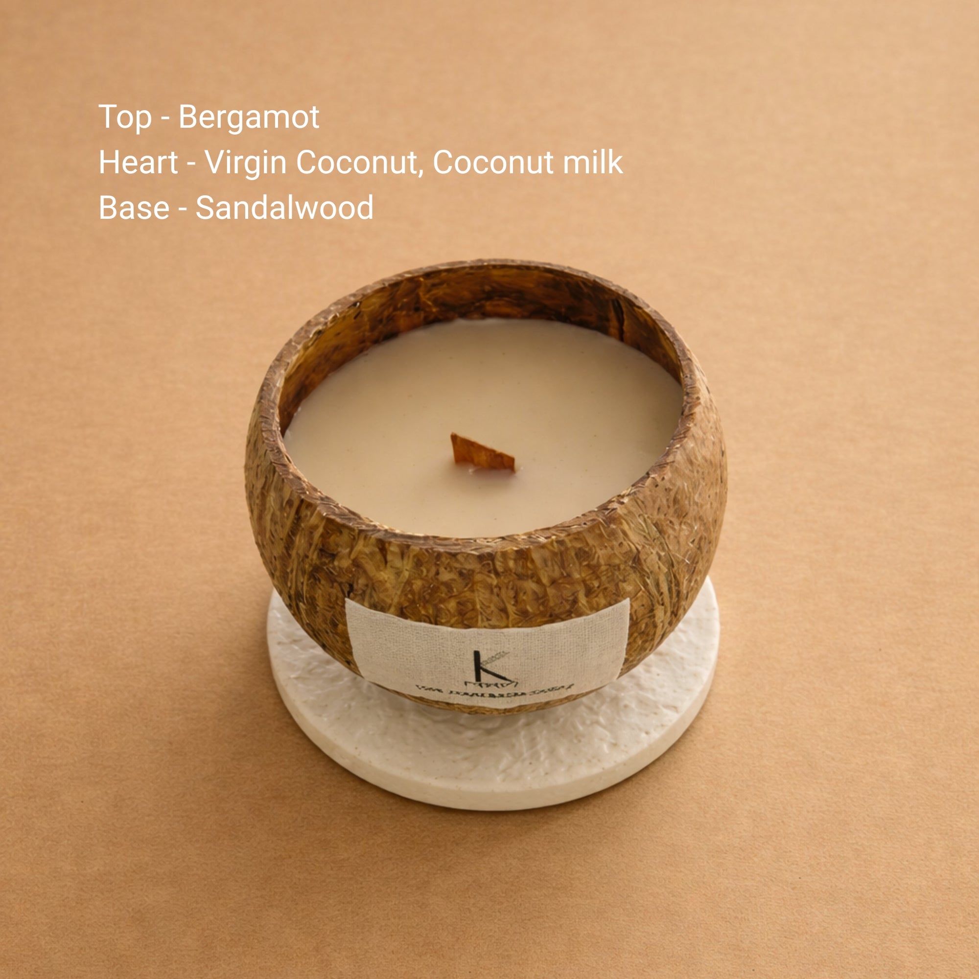 Natural wax plant based candle in a coconut shell with a label on a gray background