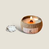 Goa Breeze coconut shell candle with a burning wick, hand-poured in a natural coconut shell with plant wax and essential oils. The candle has a fresh and tropical scent, a unique and stylish design, and comes with a wooden lid.