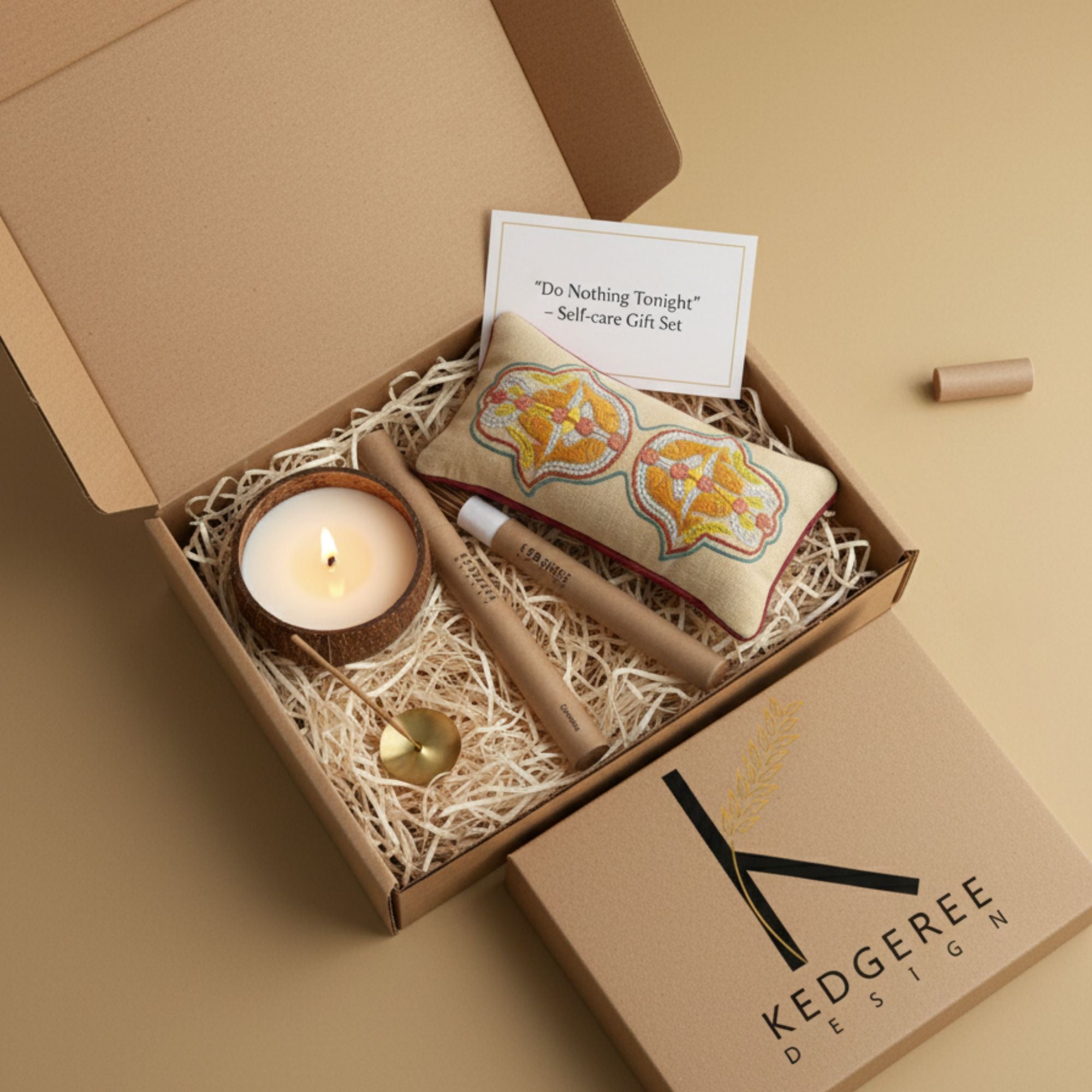 Gift set with plant based aromatherapy candle, meditation and massage eye pillow, and natural incense stick in a box labeled 'Kedgeree Design'.