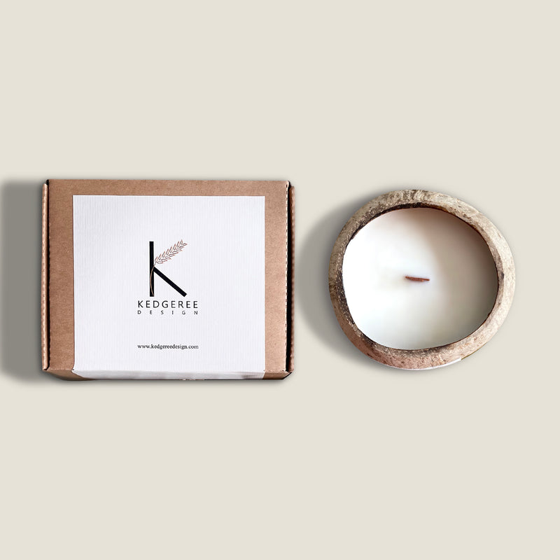 Goa Breeze coconut shell candle with a burning wick, hand-poured in a natural coconut shell with plant wax and essential oils. The candle has a fresh and tropical scent, a unique and stylish design, and comes with a wooden lid. The candle comes with a plastic free packaging.