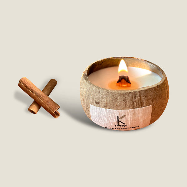 Mumbai Spice Market coconut shell candle with a burning wick, hand-poured in a natural coconut shell with plant wax and essential oils. The candle has a warm and spicy scent, a unique and stylish design, and comes with a wooden lid.
