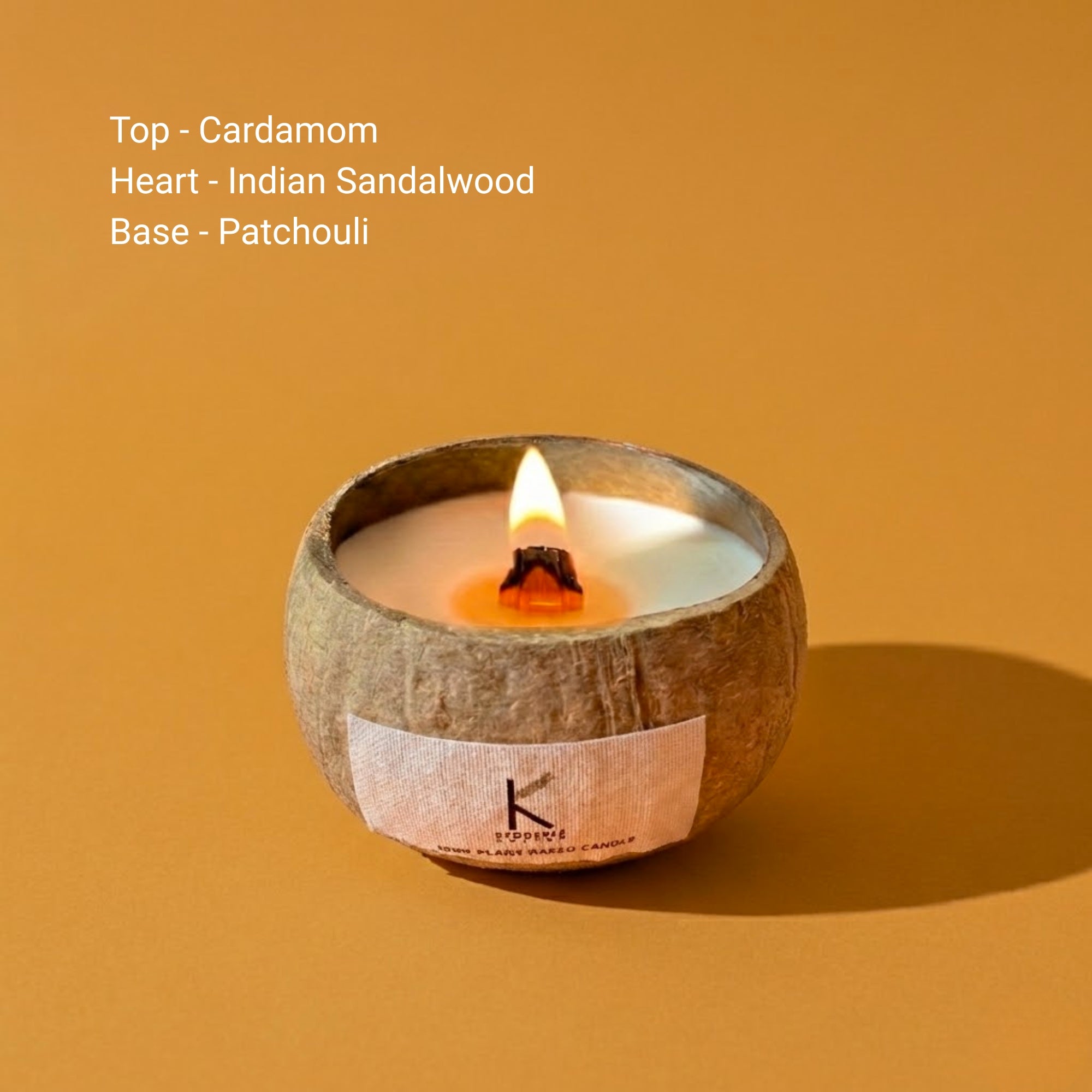 Soy wax Candle in a coconut shell with wooden sticks on a neutral background