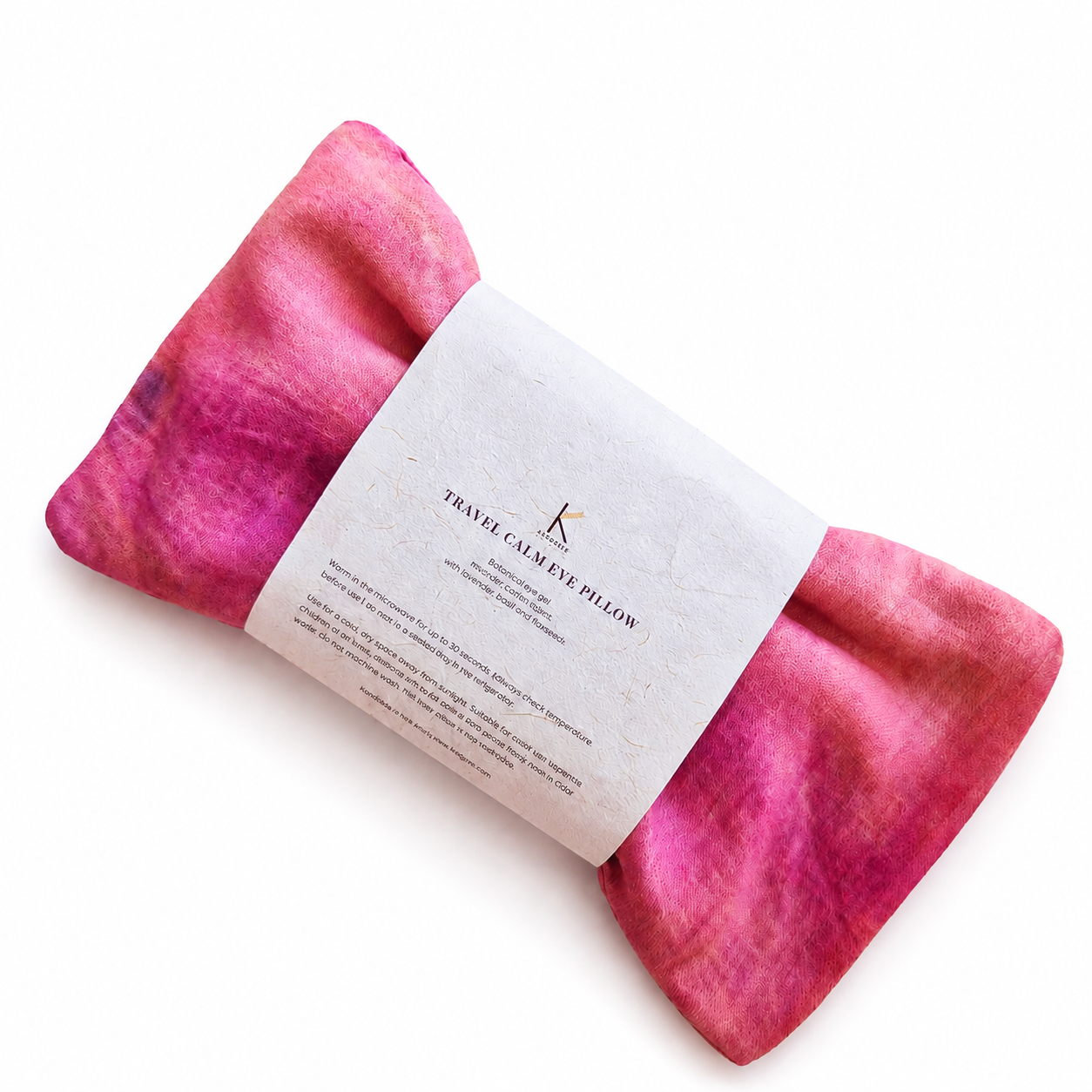 Botanically dyed Pink travel eye pillow with a label on a white background
