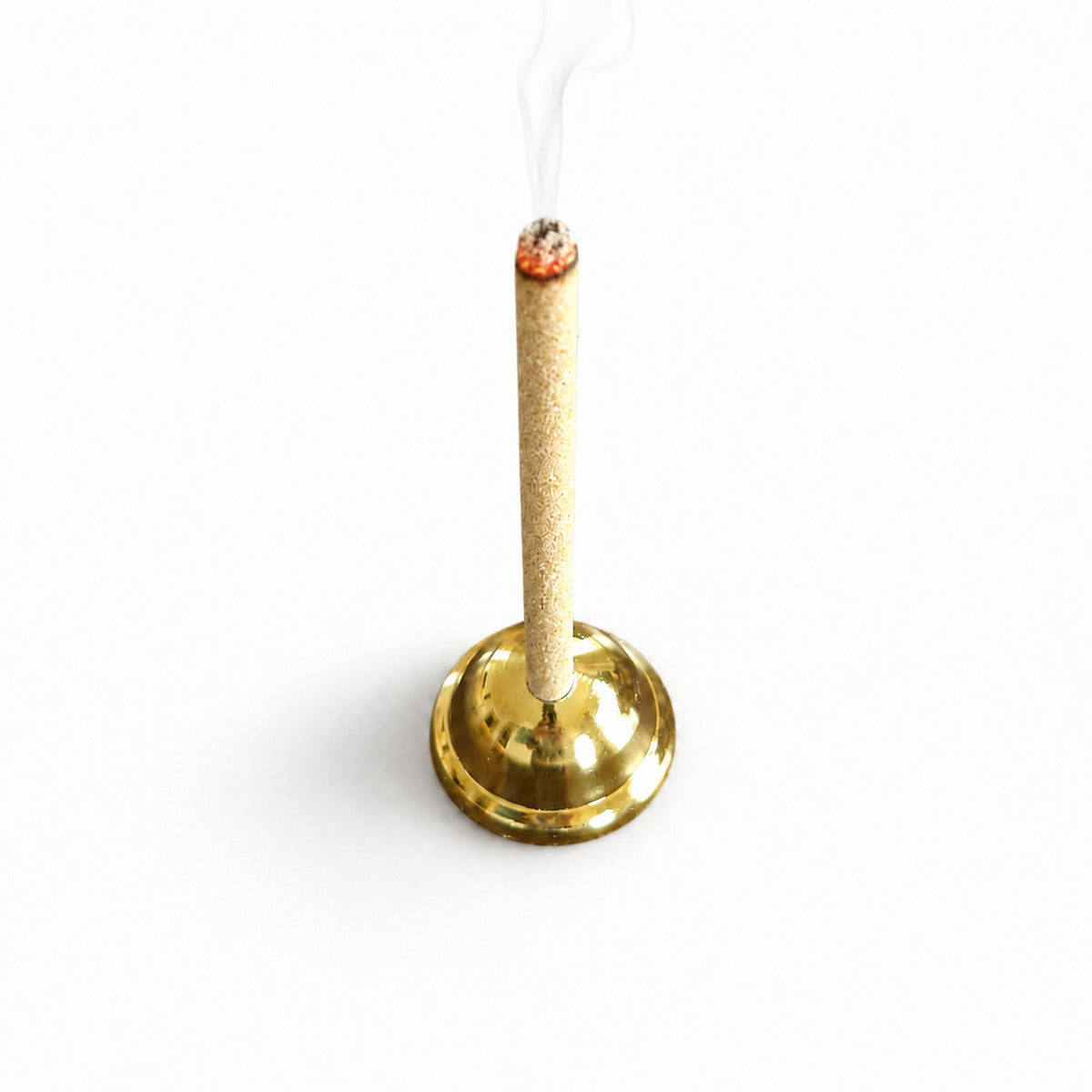 A clean burn sandalwood  incense stick burns upright in a polished gold metal holder against a clean white background, with visible smoke rising from the tip.
